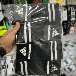 یک جین جوراب ساقدار ورزشی کش انگلیسی طرح دوخط مشکی در دست